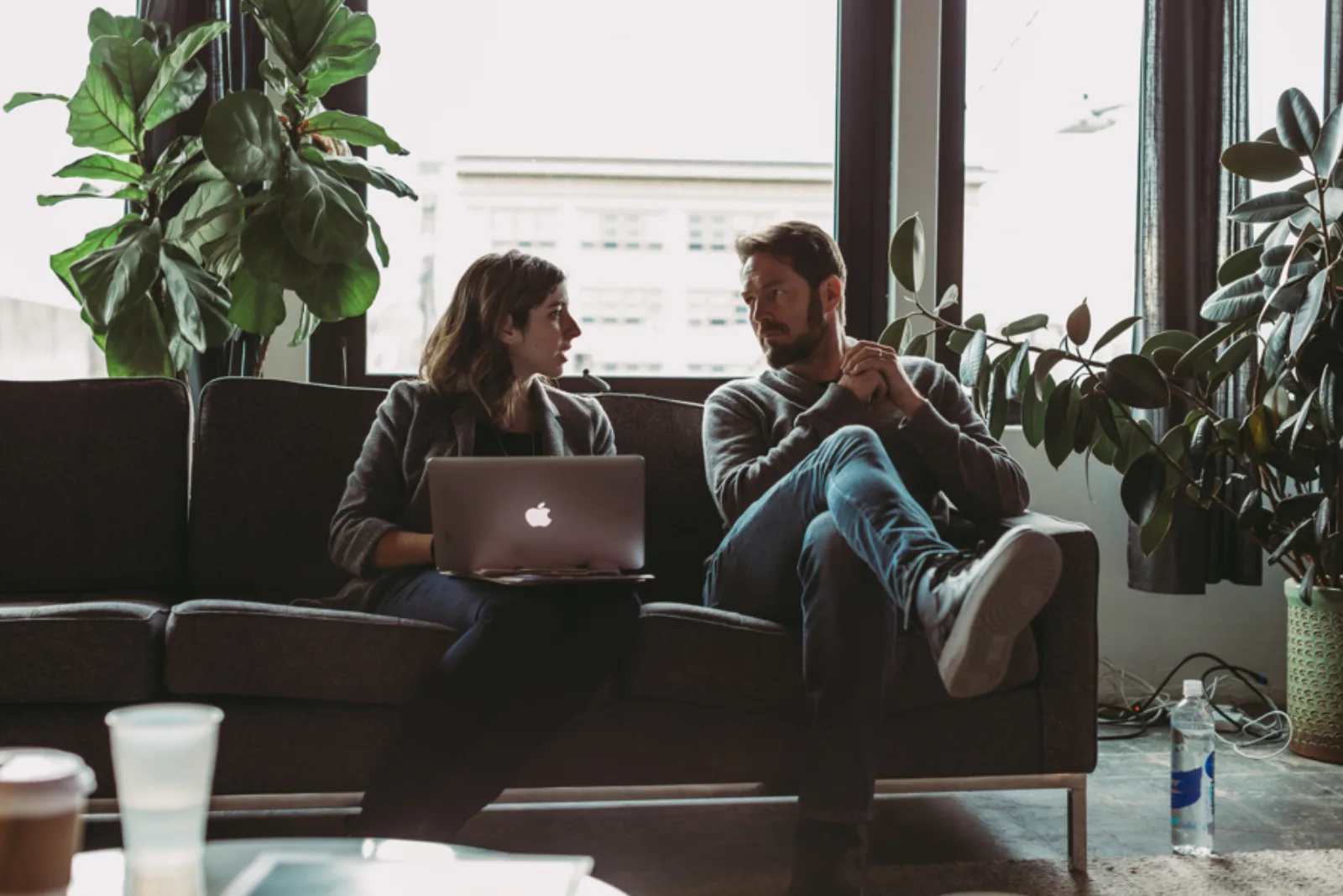 Two colleagues discussing real work beside a laptop